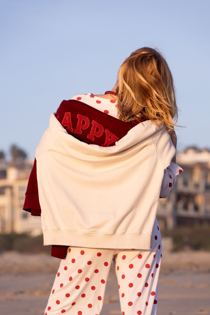 RACHOL HAPPY sweatshirt draped over the shoulder at the beach