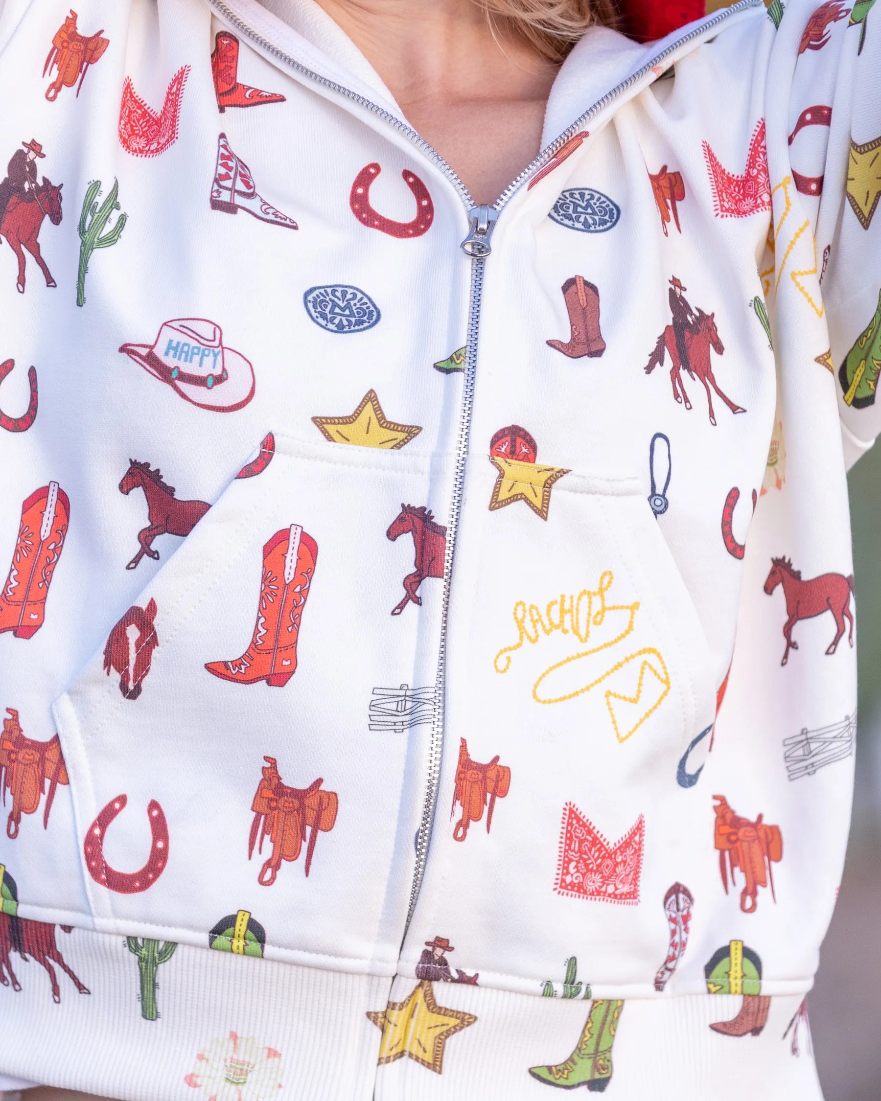 Close-up of the Howdy & Happy western print zip-up